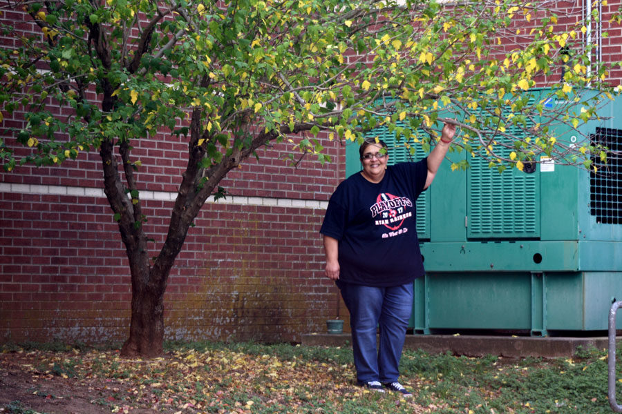 Sandra Gulley standing next to the Rose of Sharon tree she planted 20 years ago. 