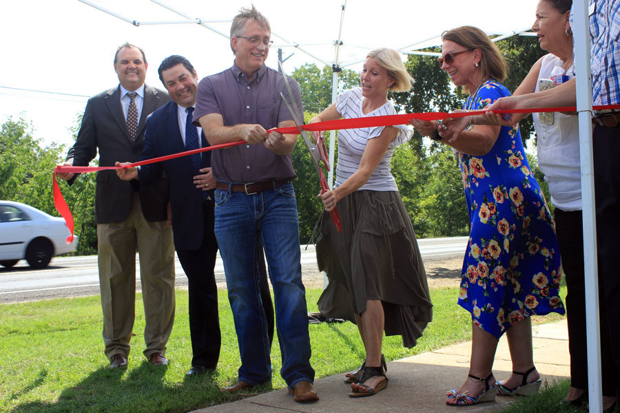 Briggs cuts the ribbon for the new sidewalk. 